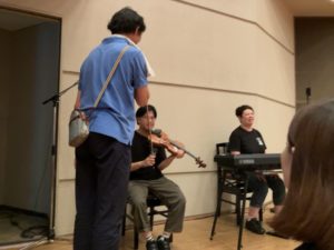 マイクをセッティングする、音響の野中さん。 ピアノのアマティーと、ヴァイオリンのカブちゃんもスタンバイ中。