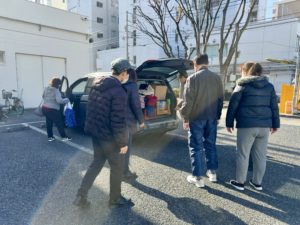 団長カーから荷物をおろすメンバーたち