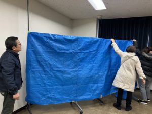 簡易早替え場を作る団長と女子たち　見守る堀越さん