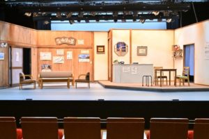 客席か見た舞台。立派なセットが建ち、ソファーなどの置き道具や、小道具もセッティングされています。