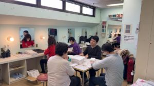 楽屋でパンフレットの折作業をするメンバーたち