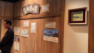 旅館ロビーの壁に掲げられた「希望の星」の看板と様々なポスター