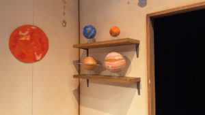 ロビー壁の棚には地球・土星・月などの惑星模型が飾られています。