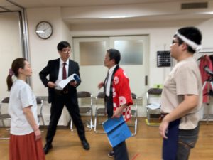 旅館の社長役　堀越さんと芝居について打ち合わせする団長
